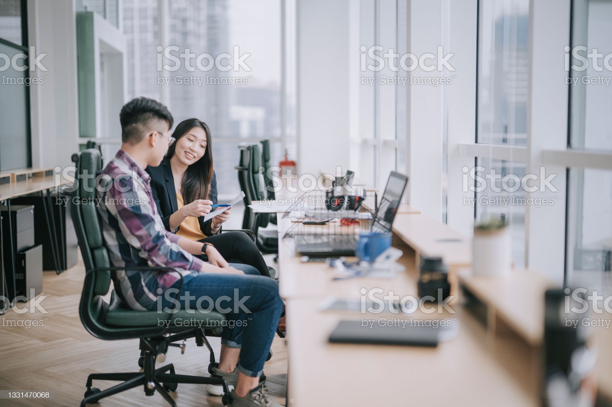 istockphoto-1331470068-2048x2048 side view Asian Chinese female colleague explaining to her trainee having discussion at office workplace