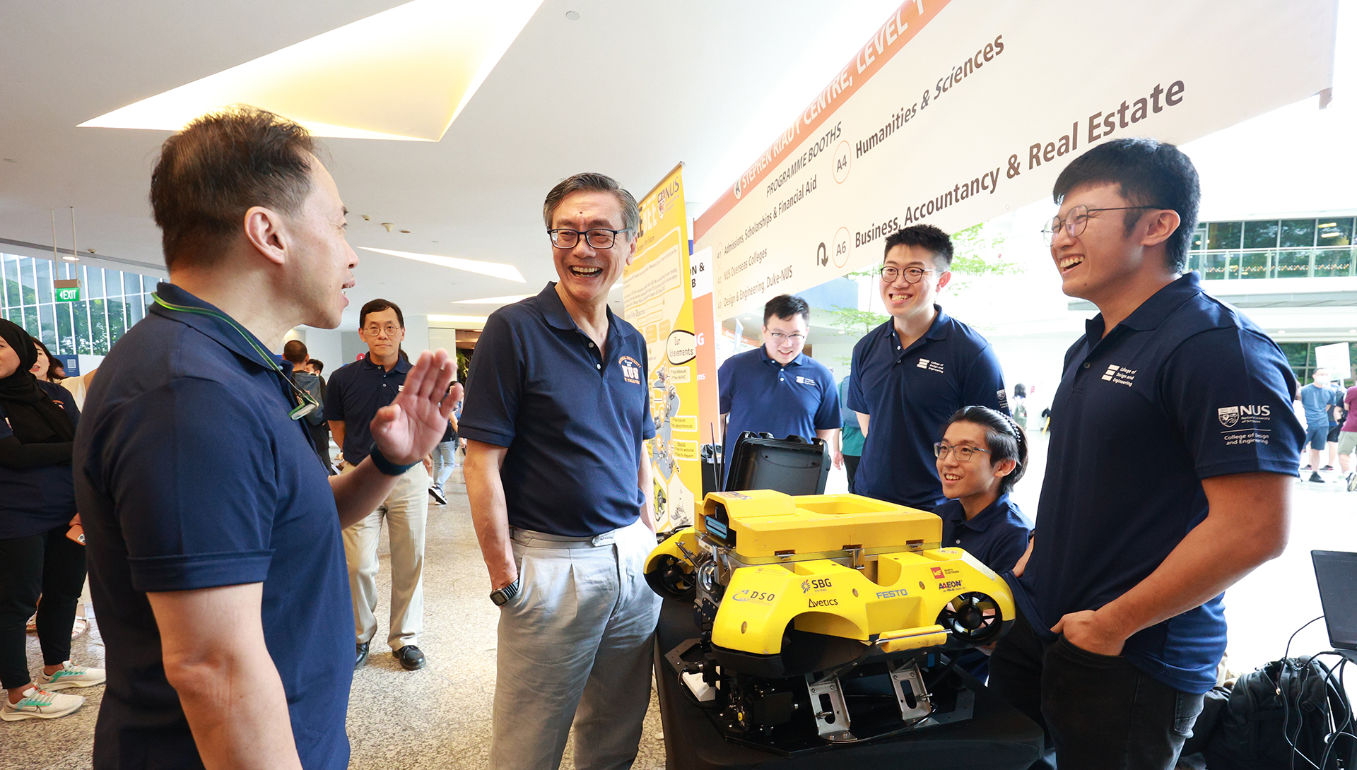 Professor Aaron Thean, Dean of the NUS College of Design and Engineering (left) and NUS President Professor Tan Eng Chye (second from left) speaking to members of Team Bumblebee, comprising students from the Mechanical, Electrical, Computer Engineering and the School of Computing disciplines. They are pictured with their award-winning Bumblebee AUV 4.0 robotic submarine.